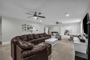 Living area with light colored carpet, recessed lighting, and ceiling fan