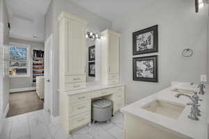 Full bath featuring double vanity and light marble finish flooring