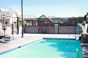 View of pool featuring a water slide and patio surround