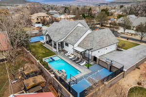 Aerial perspective of suburban area with a mountain backdrop and a pool area