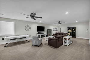 Living area featuring ceiling fan, light carpet, and recessed lighting