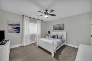 Carpeted bedroom with baseboards and a ceiling fan