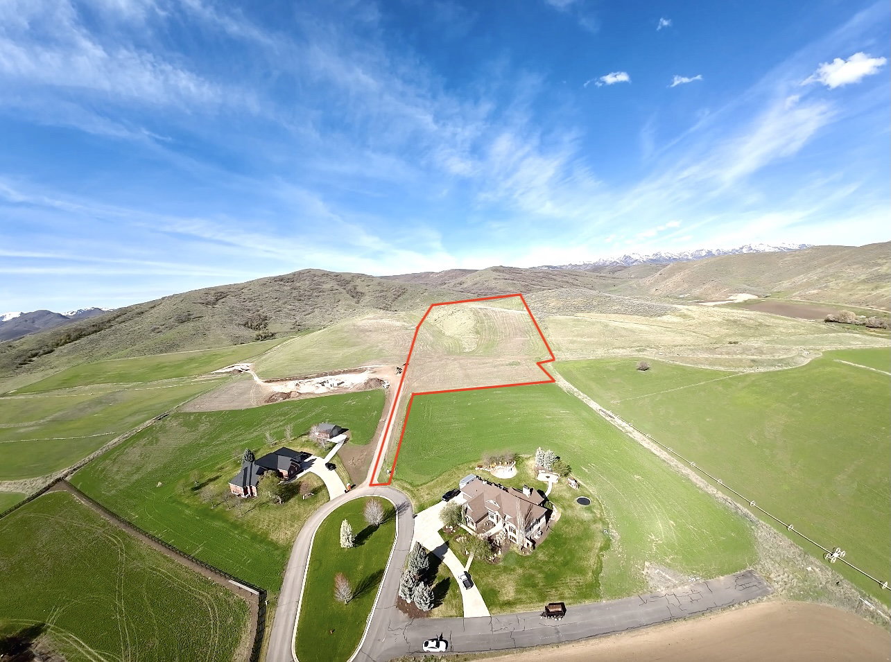 Aerial view of sparsely populated area featuring property boundaries highlighted and mountains
