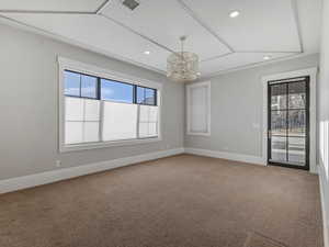 Bedroom featuring light carpet and hanging lights