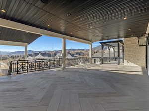 Kitchen walkout wooden deck featuring a mountain view and a patio