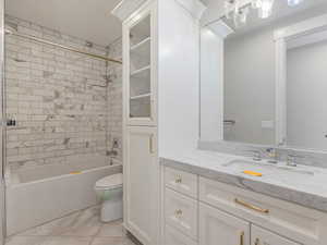 Bathroom featuring  shower combination, vanity, and light tile patterned floors