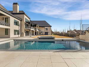 Relaxing pool / spa with a patio and a balcony