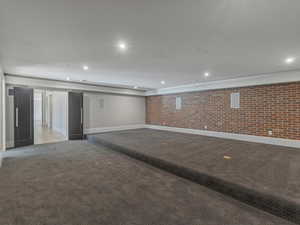 Theatre with carpet flooring, brick wall, and recessed lighting