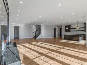 Unfurnished living room featuring a large fireplace, light wood-style flooring, and recessed lighting
