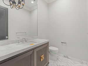 Half bathroom featuring vanity and a chandelier