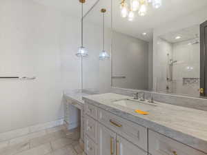 Full bath featuring vanity and tiled shower