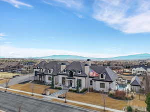 French country home with a residential view, a chimney, and stone siding