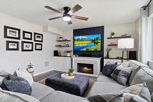 Spacious open layout with LVP flooring, recessed lighting, and custom interior design touches surrounding a cozy fireplace.