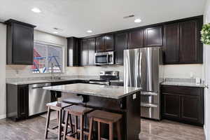 Kitchen featuring floor-to-ceiling cabinetry, granite countertops, stainless steel appliances, new dishwasher, and under-cabinet lighting.
