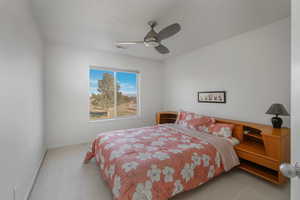 Carpeted bedroom with ceiling fan and baseboards