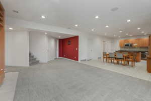 Living area featuring recessed lighting, light colored carpet, and light tile patterned floors
