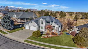 View of front facade featuring a front lawn, driveway, an attached garage, and stucco siding