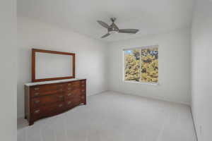 Unfurnished room featuring light carpet and a ceiling fan