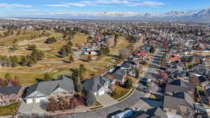 Aerial perspective of suburban area featuring a golf club and mountains