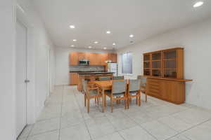 Dining room with light tile patterned flooring and recessed lighting