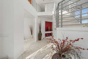 Corridor featuring a high ceiling, tile patterned floors, and recessed lighting