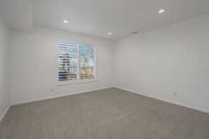 Spare room featuring light colored carpet and recessed lighting