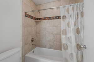 Bathroom with shower / tub combo and toilet