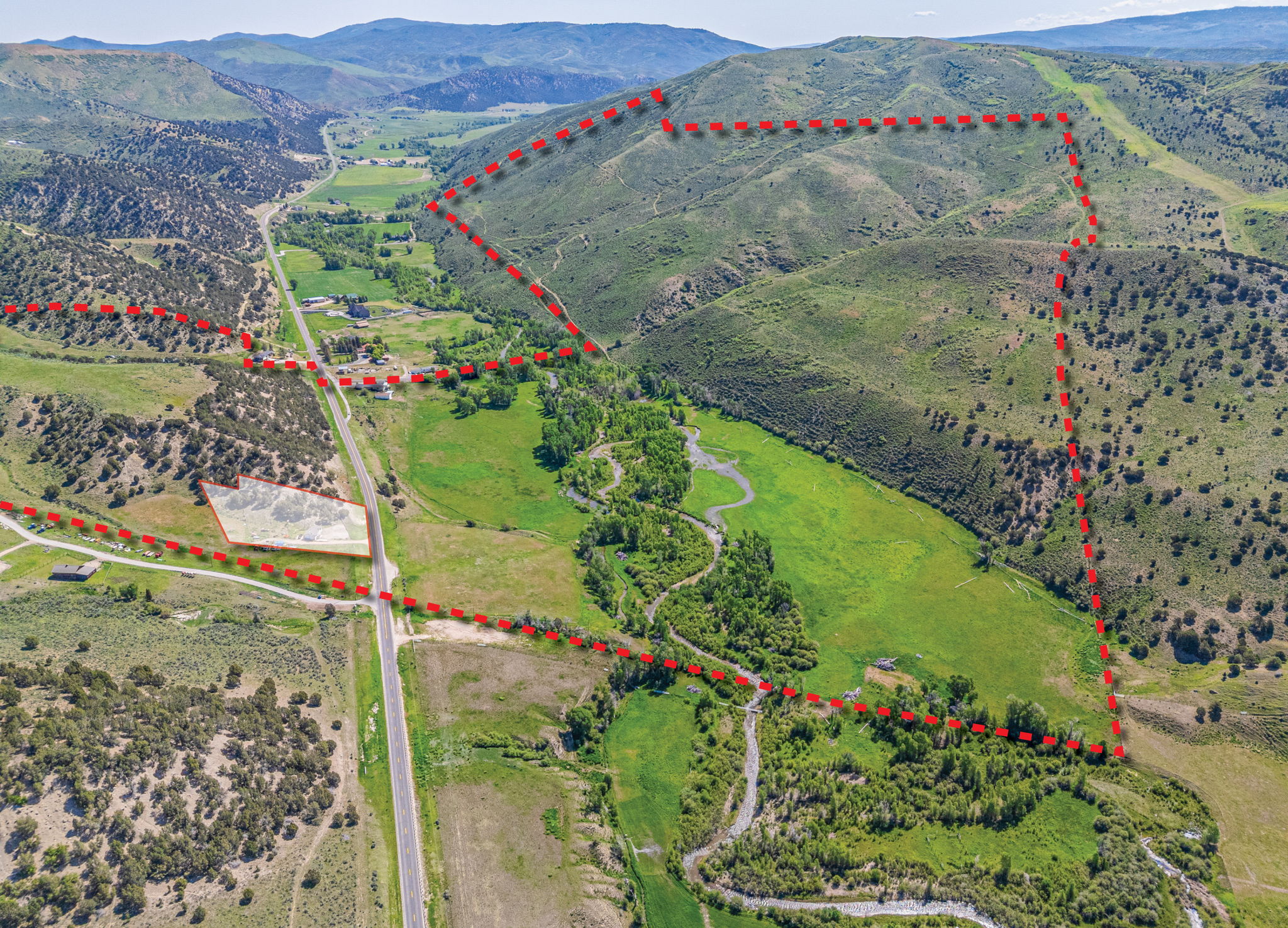 Overview of rural landscape with property boundaries highlighted and a mountainous background