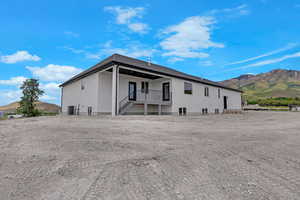 Back of property with a mountain view, stucco siding, and a patio area