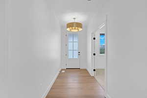 Doorway featuring baseboards and wood finished floors