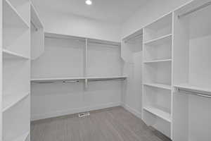 Walk in closet with light colored carpet