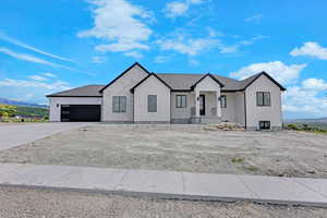 Modern farmhouse style home featuring a mountain view, stucco siding, driveway, and an attached garage