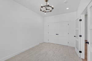 Unfurnished dining area with hanging lights and light carpet