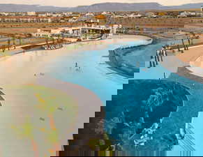 Pool at dusk featuring a mountain view and a community pool