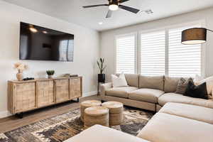 Living room with wood finished floors, a ceiling fan, plenty of natural light, and recessed lighting