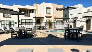 View of patio with outdoor dining space, a pool, and a hot tub