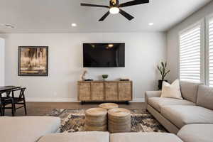 Living room featuring ceiling fan, wood finished floors, and recessed lighting
