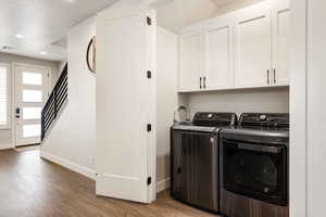 Laundry area featuring cabinet space, dark wood-style flooring, washing machine and clothes dryer, and recessed lighting