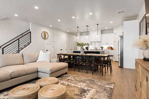 Living area with light wood-style flooring and recessed lighting