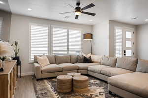 Living area featuring a ceiling fan, recessed lighting, and wood finished floors