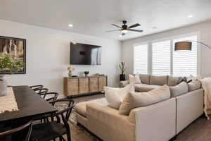 Living room with dark wood-style flooring, a ceiling fan, and recessed lighting