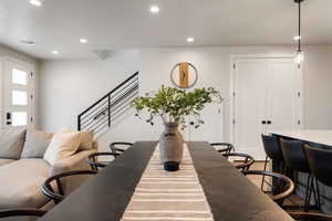 Dining space with recessed lighting and stairs
