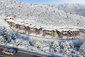 Snowy aerial view featuring a mountain view and a residential view