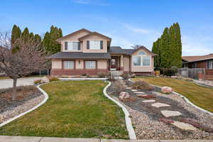 Split level home featuring stucco siding, a shingled roof, and brick siding