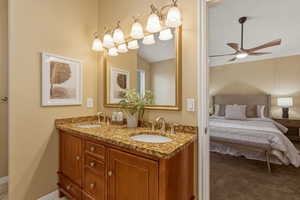 Full bath featuring double vanity, a ceiling fan, and ensuite bathroom