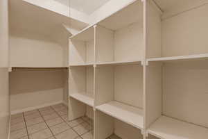Walk in closet with light tile patterned flooring