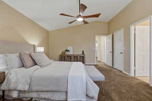 Carpeted bedroom with lofted ceiling and ceiling fan