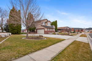 Traditional-style house featuring a residential view, driveway, a front yard, and brick siding
