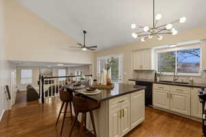 Kitchen featuring lofted ceiling, dark wood-style flooring, backsplash, open floor plan, and a center island