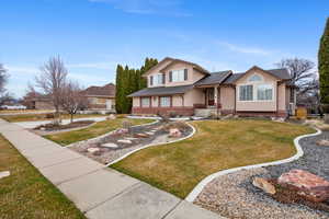 View of front facade featuring a porch, a front yard, and stucco siding